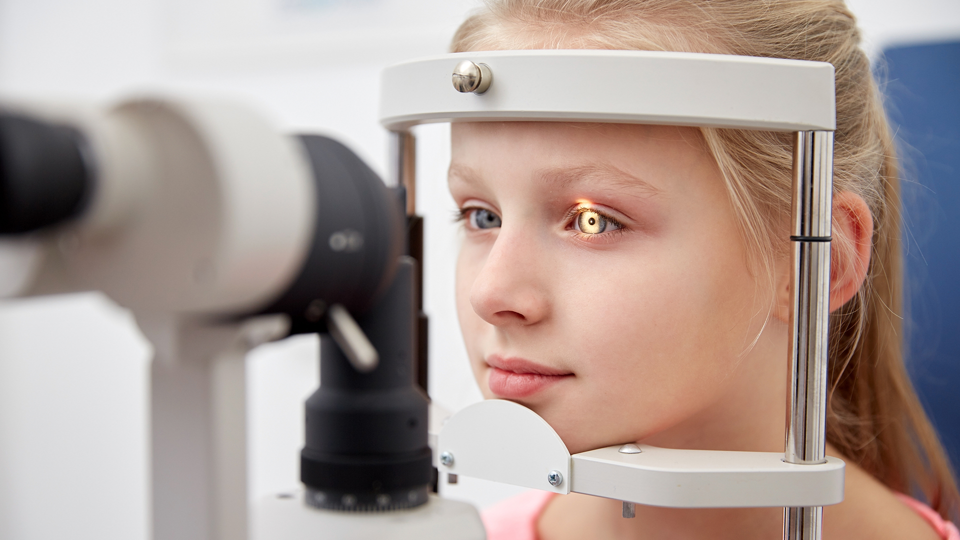 girl checking vision with tonometer at eye clinic